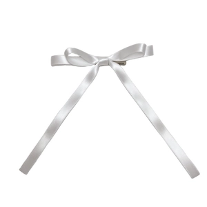 Dettaglio ravvicinato di un fermaglio per capelli a doppio fiocco in raso bianco con clip