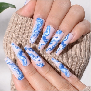 Long almond-shaped press-on nails with blue and white marble pattern on pink base
