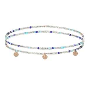 Détail d'une chaîne de taille perlée à double rang avec perles bleues et pendentifs dorés