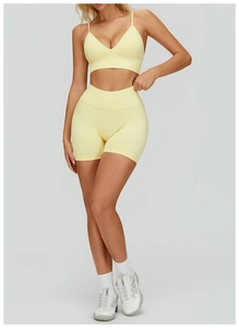 Detail view of seamless pale yellow yoga set with thin straps and high waist shorts