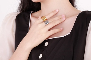Close-up of gold and silver tree of life cut-out rings on a model's hand