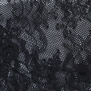 Macro shot of detailed floral lace pattern and intricate mesh texture on black corset top