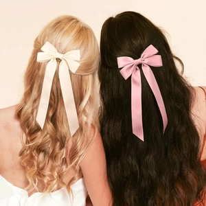 Close-up of ballet style satin ribbon bows in cream and pink on female hair