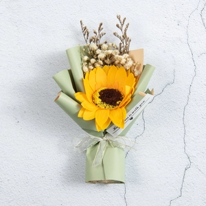 Close-up of handmade sunflower bouquet with baby's breath in green gift wrap