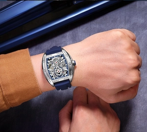 Close-up of MEGIR tonneau skeleton mechanical watch with silver case on a male wrist