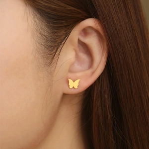 Close-up of elegant gold butterfly stud earring with cubic zirconia on model's ear