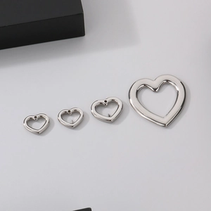 Set of four silver stainless steel hollow heart-shaped pendant charms in various sizes