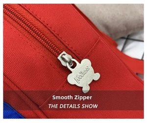 Close-up of red canvas school bag featuring a cute bear-shaped zipper pull by Miledi