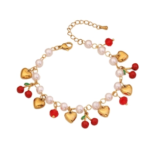 Cute fruit bracelet with pearls, gold heart charms and red cherry pendants on white base