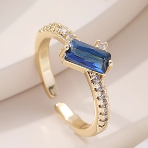 Detail shot of 18K gold ring with rectangle blue gemstone and white zircon paving