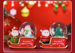 Macro detail of Santa Claus on red sled snow globes with Merry Christmas text