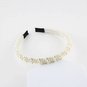 Close-up of pearl woven headband with black fabric protective ends on white background