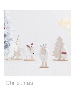Close-up of wooden Christmas reindeer and trees with white plush details and JOY LOVE PEACE text