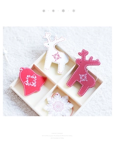 Close-up of Nordic wooden reindeer, snowflake and bell ornaments in a wooden grid box