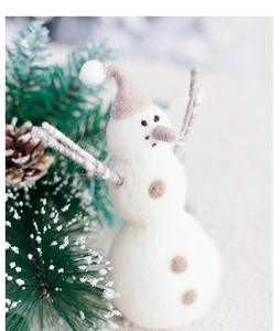 Detail of handcrafted wool felt snowman ornament with Nordic winter decoration