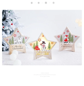 Close-up of Nordic wooden star LED ornaments with Merry Christmas engraving on plush surface