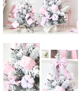 Pink mini Christmas tree with decorative bows, gift boxes and realistic artificial snow