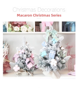 Close-up of pink macaron-style mini Christmas trees with snow flocking and silk ribbons