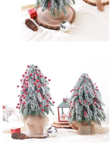 Close-up of mini snow-flocked Christmas tree with red berries and burlap base decor