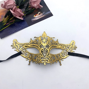 Close-up of golden lace masquerade mask with intricate embroidery and black ribbons