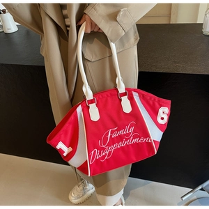 Detail of red bowling tote bag with white embroidery and mesh panels on a model