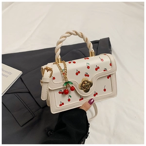 Detailed view of cherry print handbag with twist handle and golden flower clasp