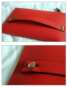 Macro detail van rode envelop clutch met lychee leer textuur en gouden piramide studs