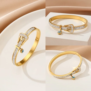 Golden buckle bangle with zircon and blue evil eye charm shown in multi-angle views