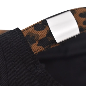 Detalle de gorra de algodón negro con correa de leopardo y hebilla de metal plateado