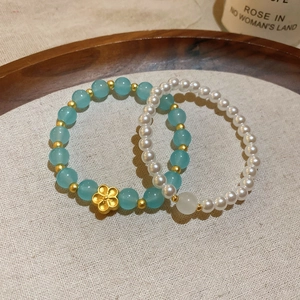 Primer plano de pulseras de cuentas de estilo chino con piedras azules y perlas.