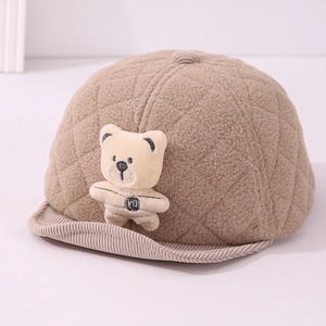 Detailed view of plush teddy bear doll and quilted fleece texture on infant winter cap
