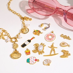 Detailed macro view of assorted gold-tone ocean-themed enamel charms and pendants