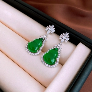 Detail of green gourd earrings with inlaid diamonds in a beige velvet jewelry box