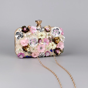 Macro detail of champagne evening bag with 3D handmade flowers and gemstone lock
