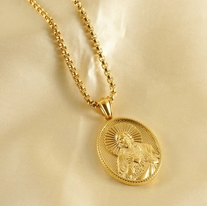 Macro view of gold 18K stainless steel box chain and Jesus relief oval pendant