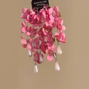 Close-up of pink resin flower earrings with silver posts and white teardrop pearls