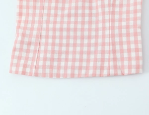 Nahaufnahme von rosa-weißem Gingham-Stoff mit Doppelnadelstich und Baumwolltextur