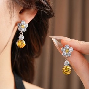 Detailed close-up of ziron flower pendant earrings featuring yellow and clear stones
