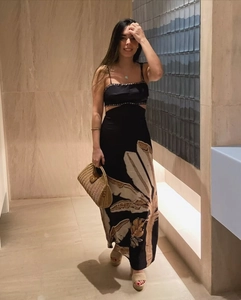 Detailed view of cutout waist design and tropical leaf print on black maxi dress