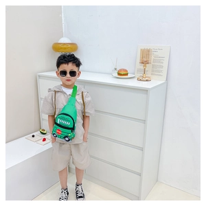 Detail of green school bus shaped kids chest bag with adjustable strap and cartoon design