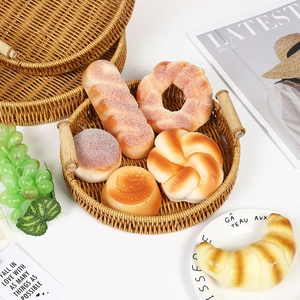 Handwoven round rattan fruit tray with wooden handles for kitchen and home storage