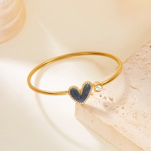 Golden stainless steel heart bangle featuring a blue enamel inlay and sparkling zircon