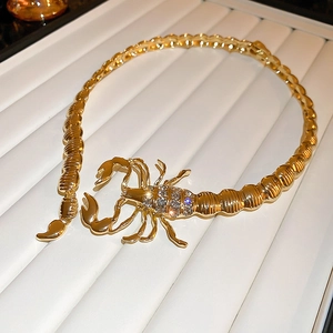 Detailed macro view of gold scorpion choker with sparkling rhinestone inlay and metal texture