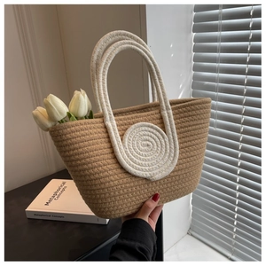 Detail view of woven cotton rope handbag with white thick rope handles and tulip decor