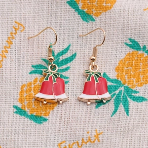 Christmas red bell earrings with gold hooks on a decorative fruit pattern background