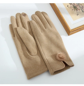 Detail view of beige wool gloves with heart-shaped touchscreen tips and fur pompom