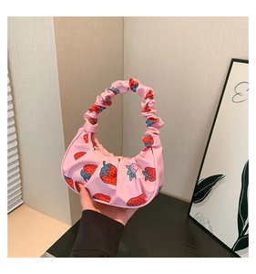 Dettaglio della borsa a spalla plissettata rosa con stampa fragola in nylon liscio