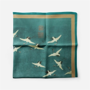Detailed view of square silk scarf featuring flying cranes and vintage seal patterns