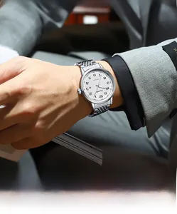 Detail of automatic mechanical watch with silver steel strap on a man wearing a business suit