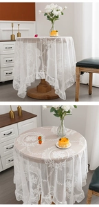 Detail of white lace tablecloth with floral embroidery and elegant ruffled hem design
